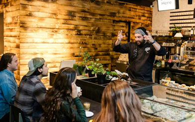 Barista explaining coffee brewing to a group during VIP Morning Market Experience.