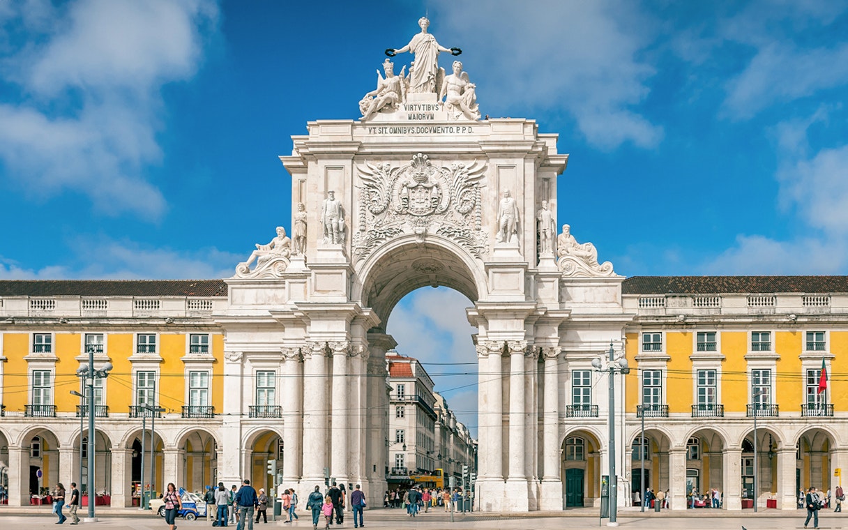 Arco da Rua Augusta in Praça do Comércio, Lisbon, Portugal with people walking.