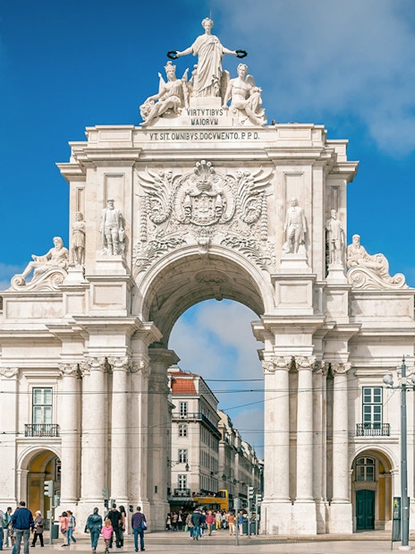 Arco da Rua Augusta in Praça do Comércio, Lisbon, Portugal with people walking.