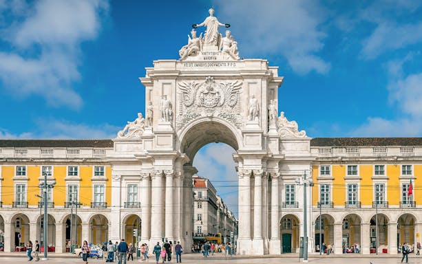Arco da Rua Augusta in Praça do Comércio, Lisbon, Portugal with people walking.