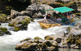 Boat navigating rapids on Hozugawa River during Kyoto day tour.
