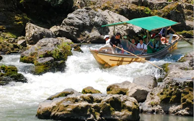 Boat navigating rapids on Hozugawa River during Kyoto day tour.