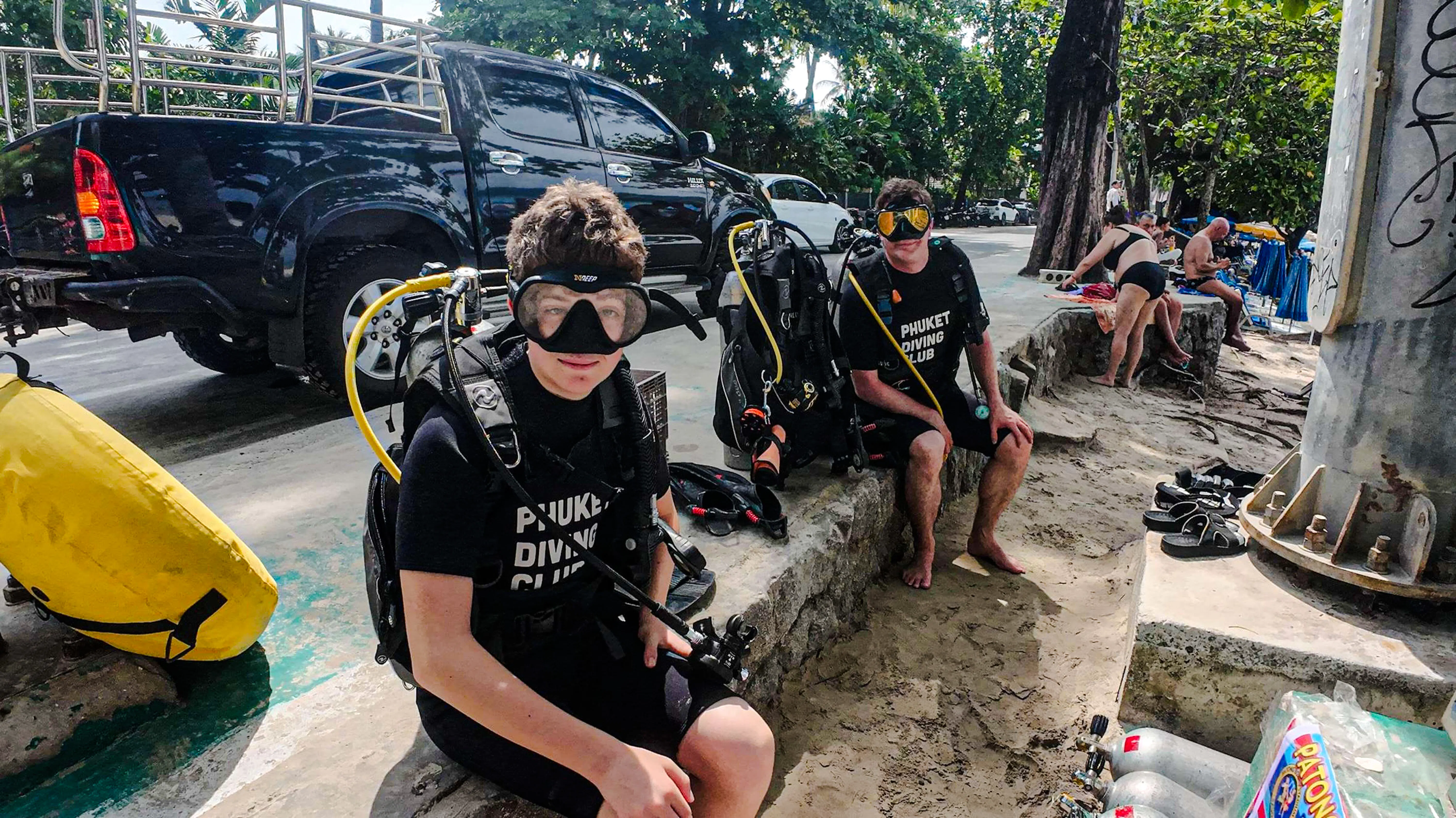 Scuba diving beginners preparing gear at Kata Beach, Phuket.