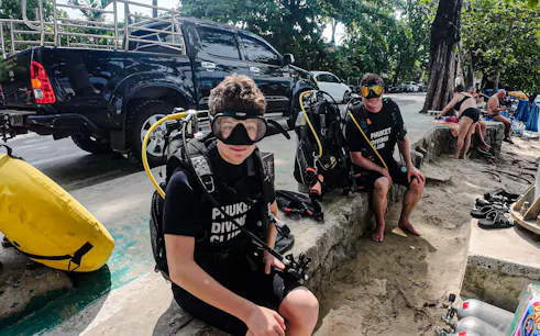 Scuba diving beginners preparing gear at Kata Beach, Phuket.