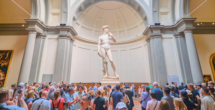 Visitors viewing Michelangelo's David sculpture at Accademia Gallery, Florence.