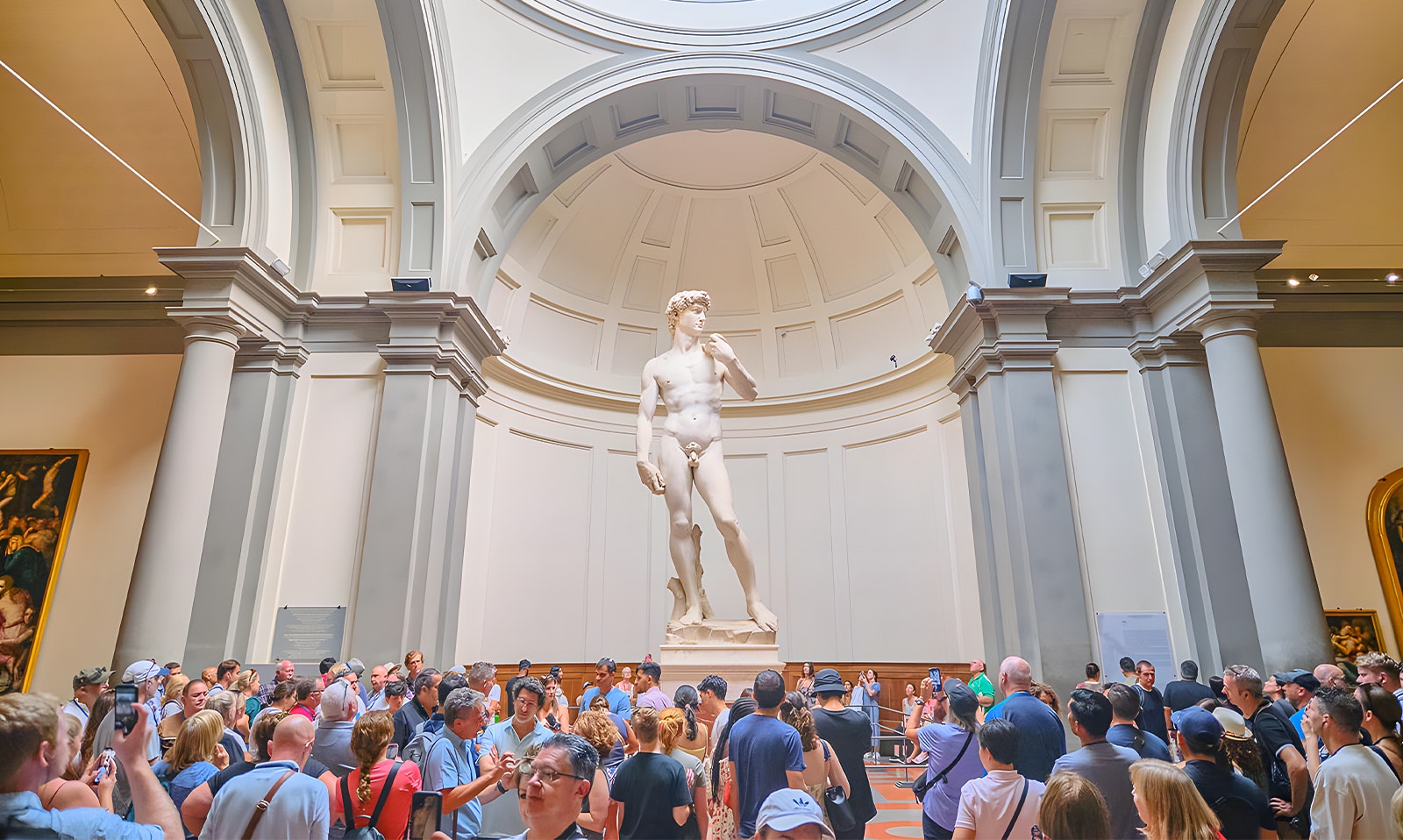 Visitors viewing Michelangelo's David sculpture at Accademia Gallery, Florence.