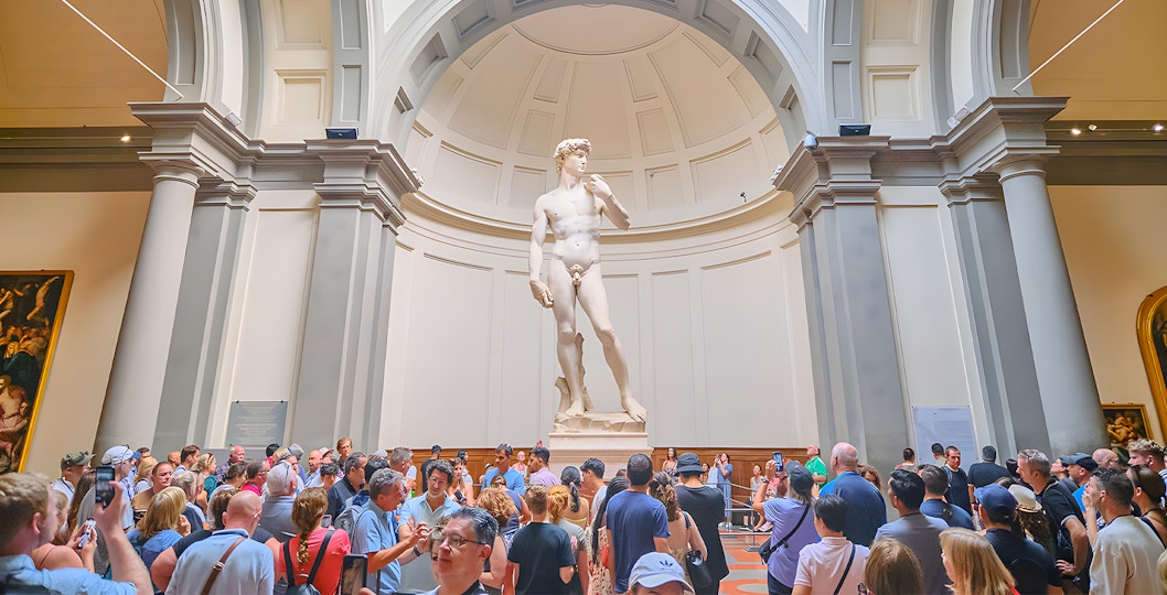 Visitors viewing Michelangelo's David sculpture at Accademia Gallery, Florence.