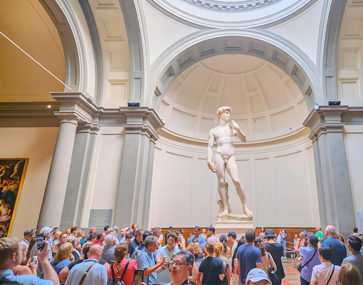 Visitors viewing Michelangelo's David sculpture at Accademia Gallery, Florence.