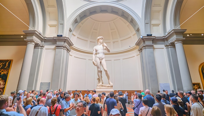 Visitors viewing Michelangelo's David sculpture at Accademia Gallery, Florence.
