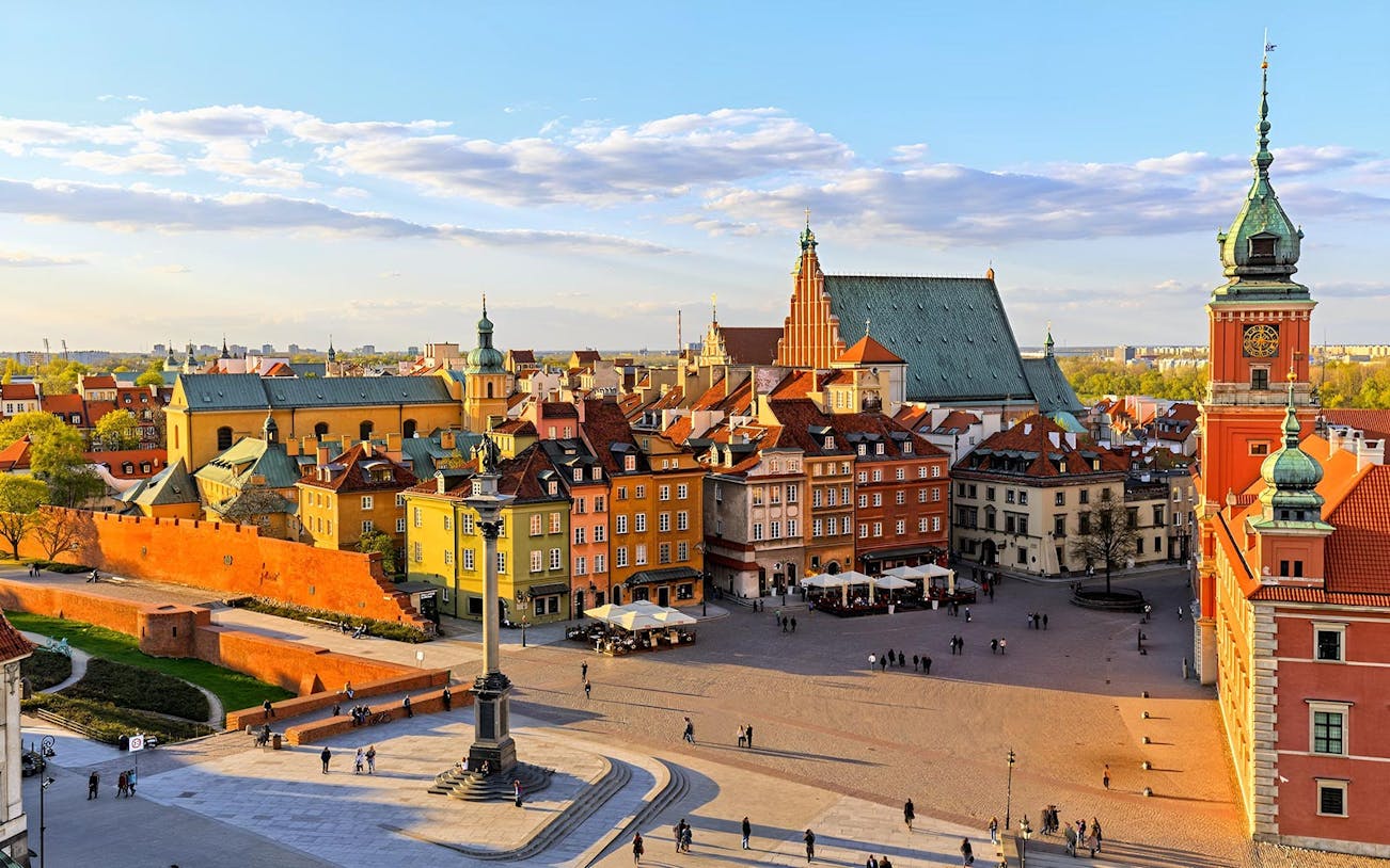 Warsaw Old Town Square with colorful buildings and Sigismund's Column.