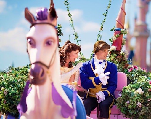 Belle and prince on a floral float during Disneyland Paris parade.