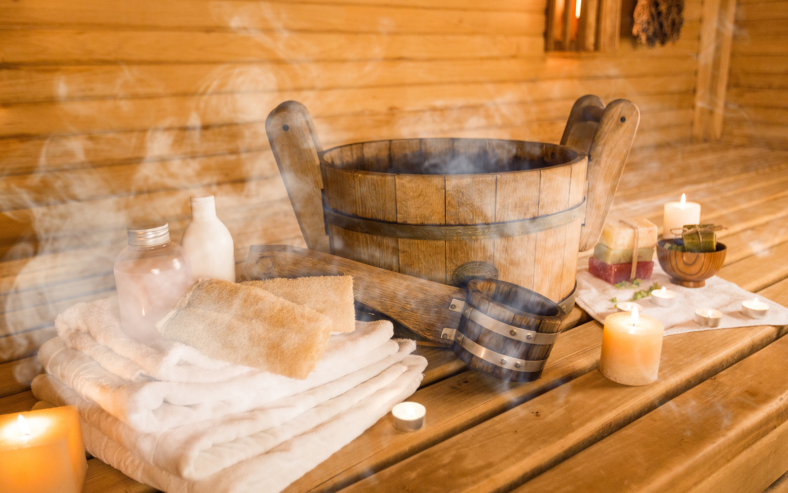 Sauna interior with wooden benches and hot stones, highlighting relaxation in a park setting.