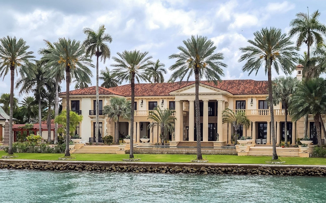 Luxury mansion with palm trees viewed from Miami Skyline Cruise.