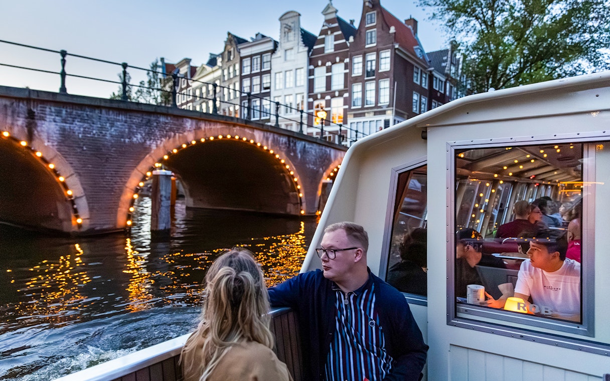 Guests enjoying the Happy Valentine Evening Cruise on Amsterdam's illuminated canal.