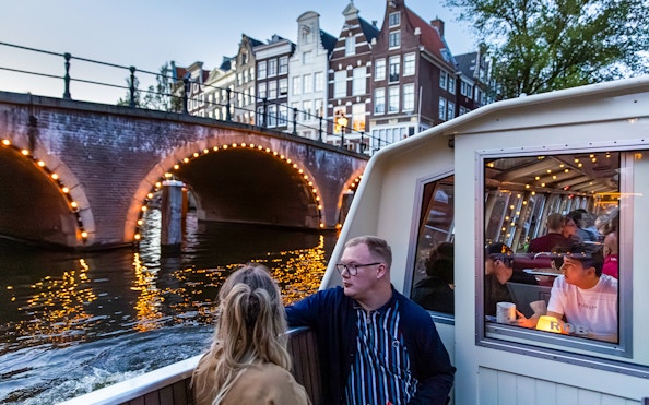 Guests enjoying the Happy Valentine Evening Cruise on Amsterdam's illuminated canal.