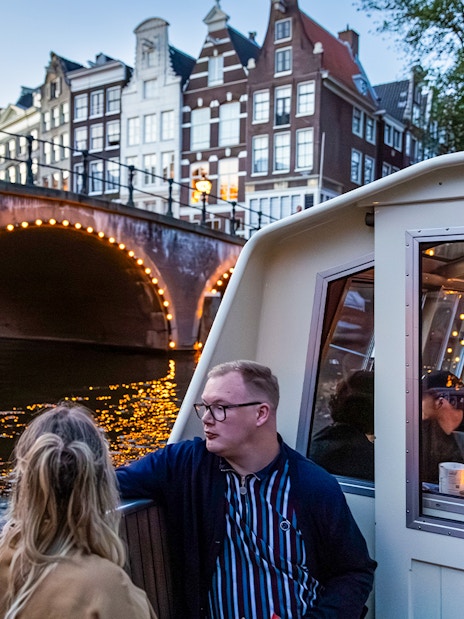 Guests enjoying the Happy Valentine Evening Cruise on Amsterdam's illuminated canal.