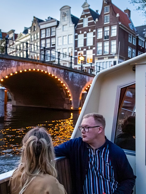 Guests enjoying the Happy Valentine Evening Cruise on Amsterdam's illuminated canal.
