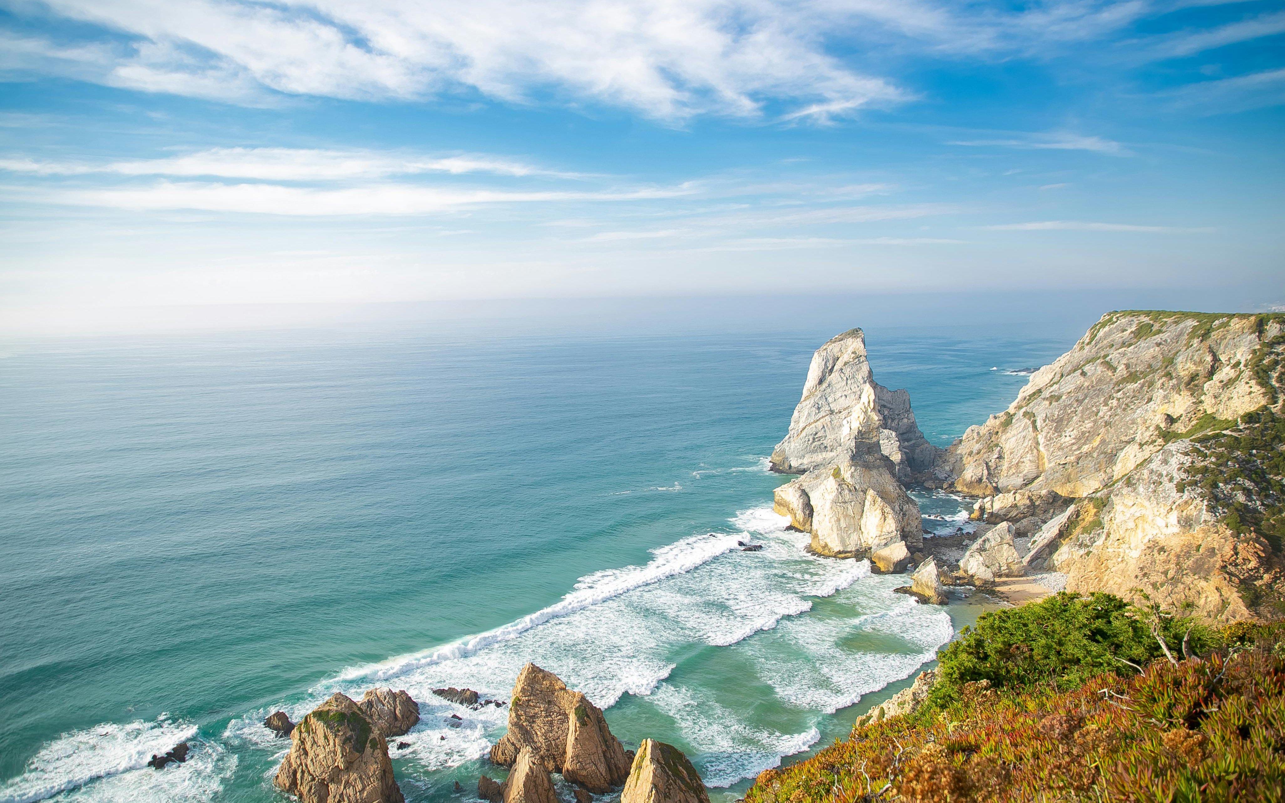 Praia da Ursa coastline with rocky cliffs and ocean waves, Sintra-Cascais Natural Park, Portugal.