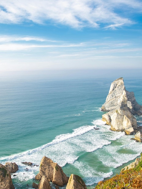 Praia da Ursa coastline with rocky cliffs and ocean waves, Sintra-Cascais Natural Park, Portugal.