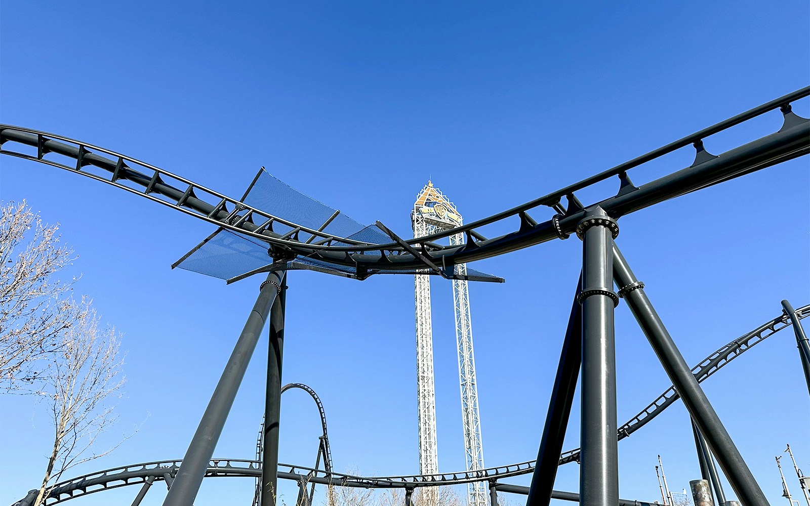 Parque Warner Madrid entrance with iconic cartoon character statues and vibrant theme park atmosphere.