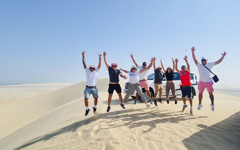 Group jumping on sand dunes during Half Day Desert Safari.