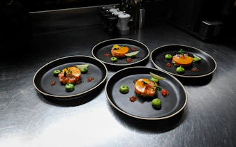 Gourmet dishes with salmon tartare and avocado mousse served in Bustronome bus, Dubai.