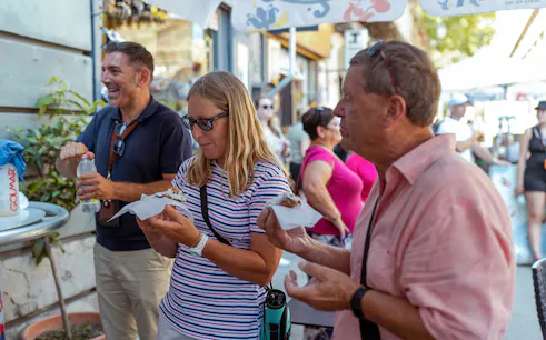Tourists enjoying street food during UNESCO Sites Walking Tour in Palermo.