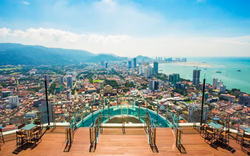 Skywalk view from The Rainbow Walk at The Top, Penang, overlooking cityscape and coastline.