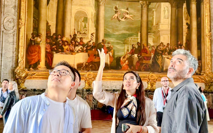 Visitors admire artwork during a guided tour at the Palace of Versailles.