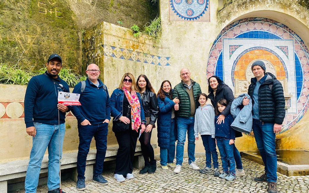 Tourists with guide at Quinta da Regaleira fountain, Sintra, Portugal.