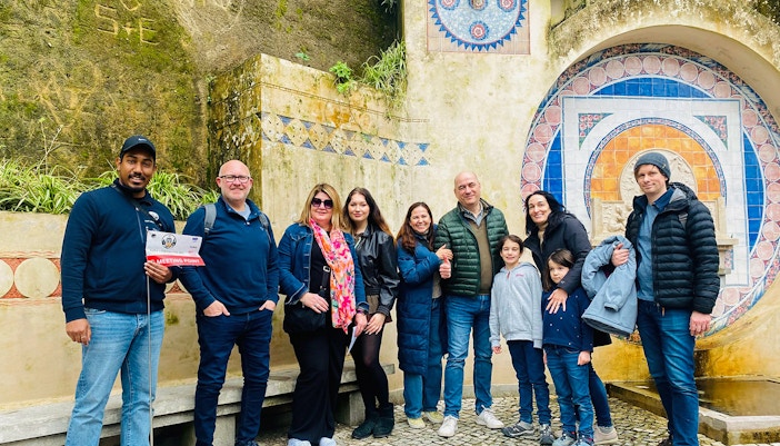 Tourists with guide at Quinta da Regaleira fountain, Sintra, Portugal.