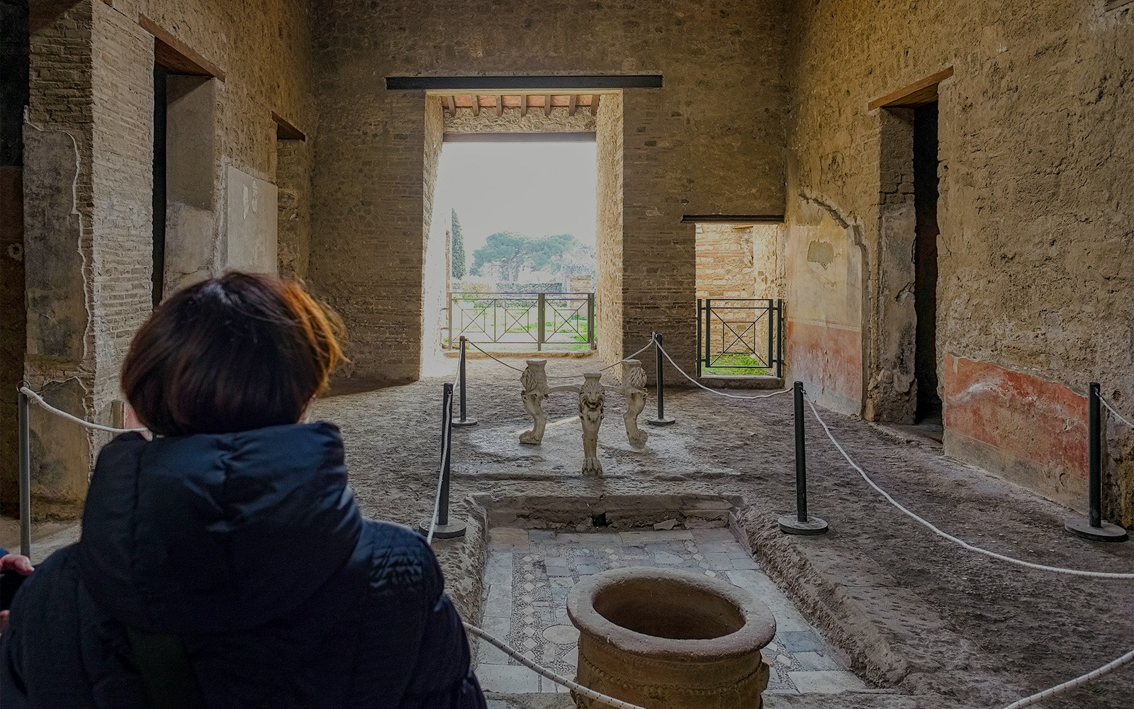 Tour guide leading tourists through the ancient Samnite House in Pompeii, Italy.