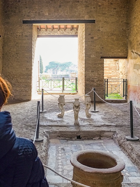 Tourists exploring the ancient Samnite House interior in Pompeii, Italy.