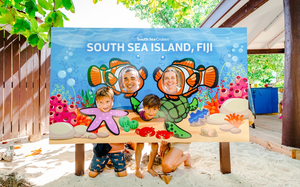 Family posing with Finding Nemo-themed cutout at South Sea Island, Fiji.