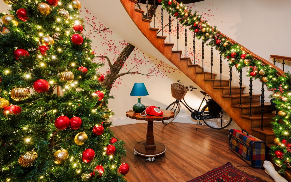 Christmas decorations on a staircase and tree at Paddington experience, London.