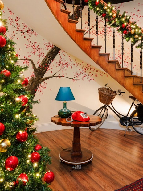 Christmas decorations on a staircase and tree at Paddington experience, London.