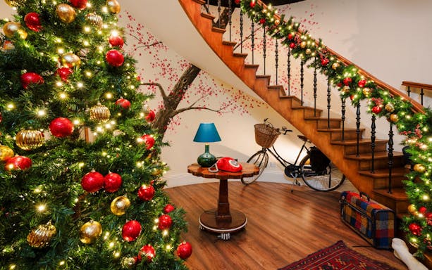 Christmas decorations on a staircase and tree at Paddington experience, London.