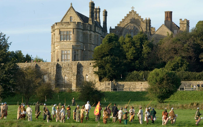 Reenactment of historical battle at Battle Abbey, England, with participants in period costumes.