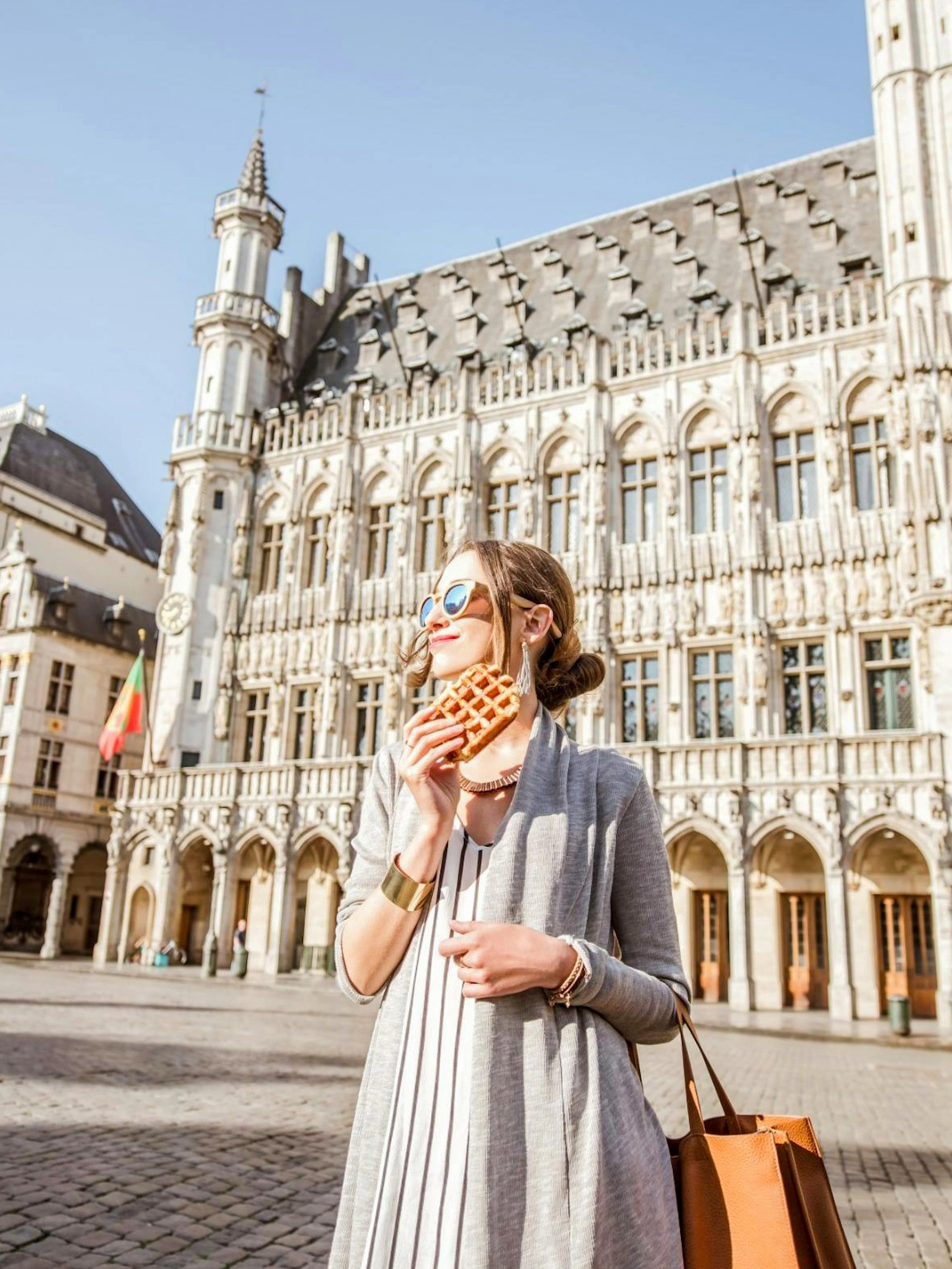 Visitor enjoying a waffle at the Grand Place in Brussels.