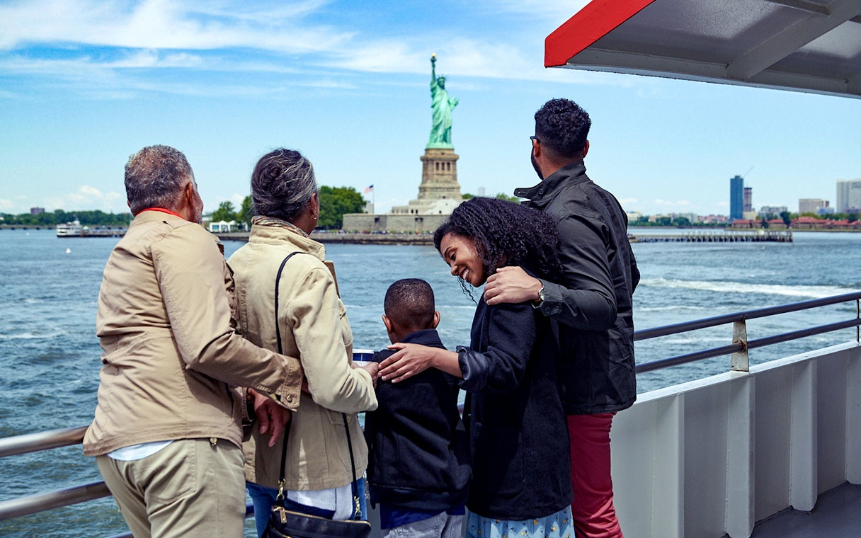 Family on a boat tour viewing the Statue of Liberty in New York City.