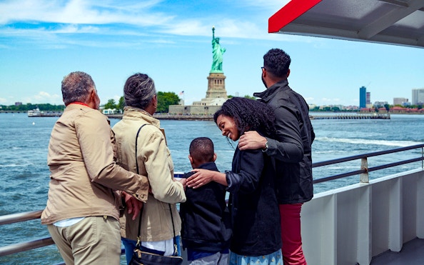 Family on a boat tour viewing the Statue of Liberty in New York City.
