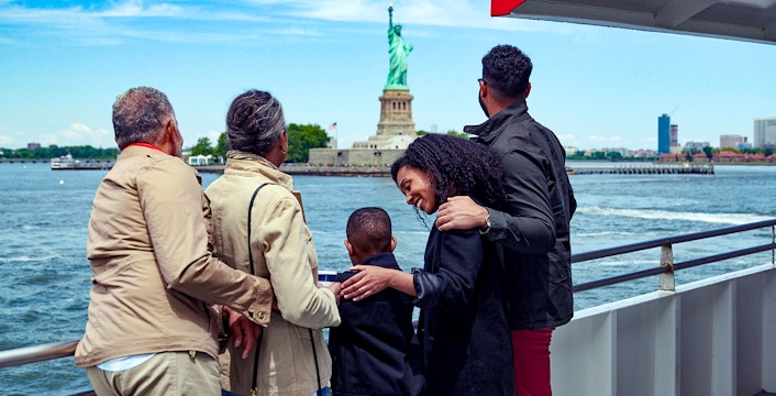 Family on a boat tour viewing the Statue of Liberty in New York City.