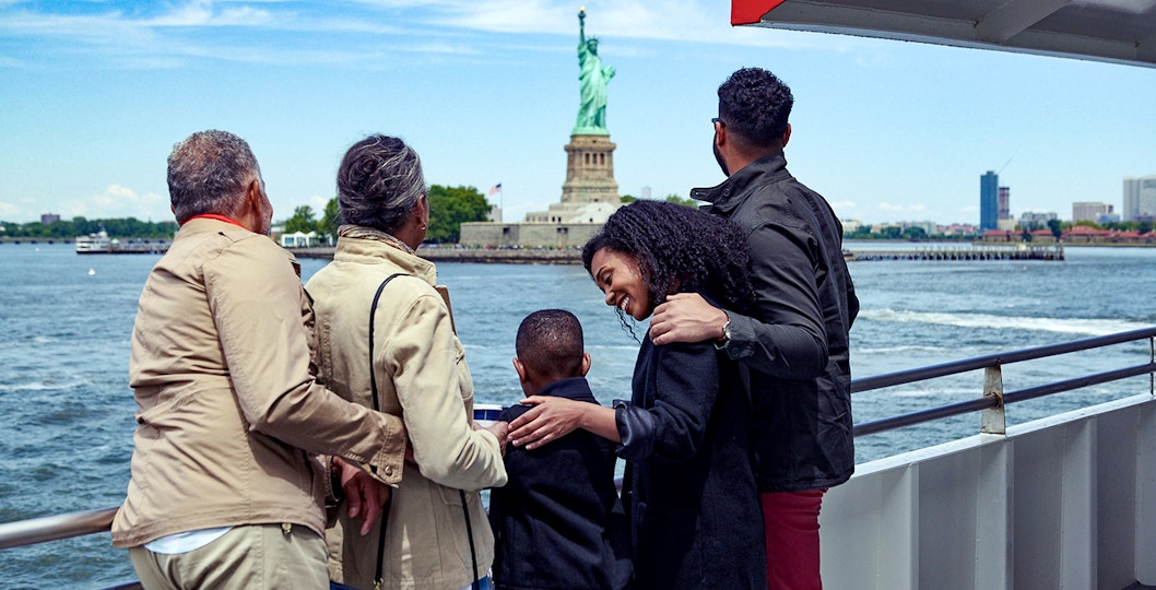 Family on a boat tour viewing the Statue of Liberty in New York City.