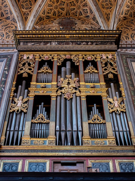 Milan Duomo Museum mechanical organ with ornate artwork panels.