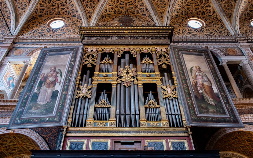 Milan Duomo Museum mechanical organ with ornate artwork panels.