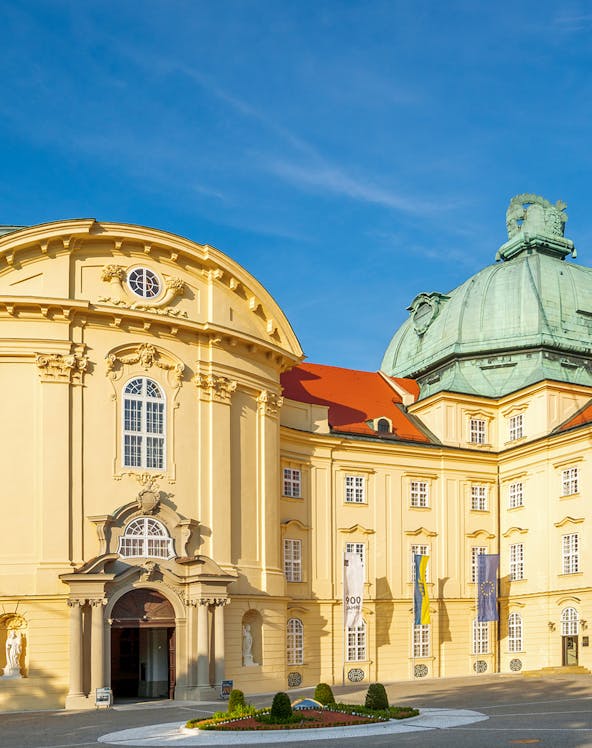 Klosterneuburg Monastery's baroque architecture in Vienna, Austria, under a clear blue sky.