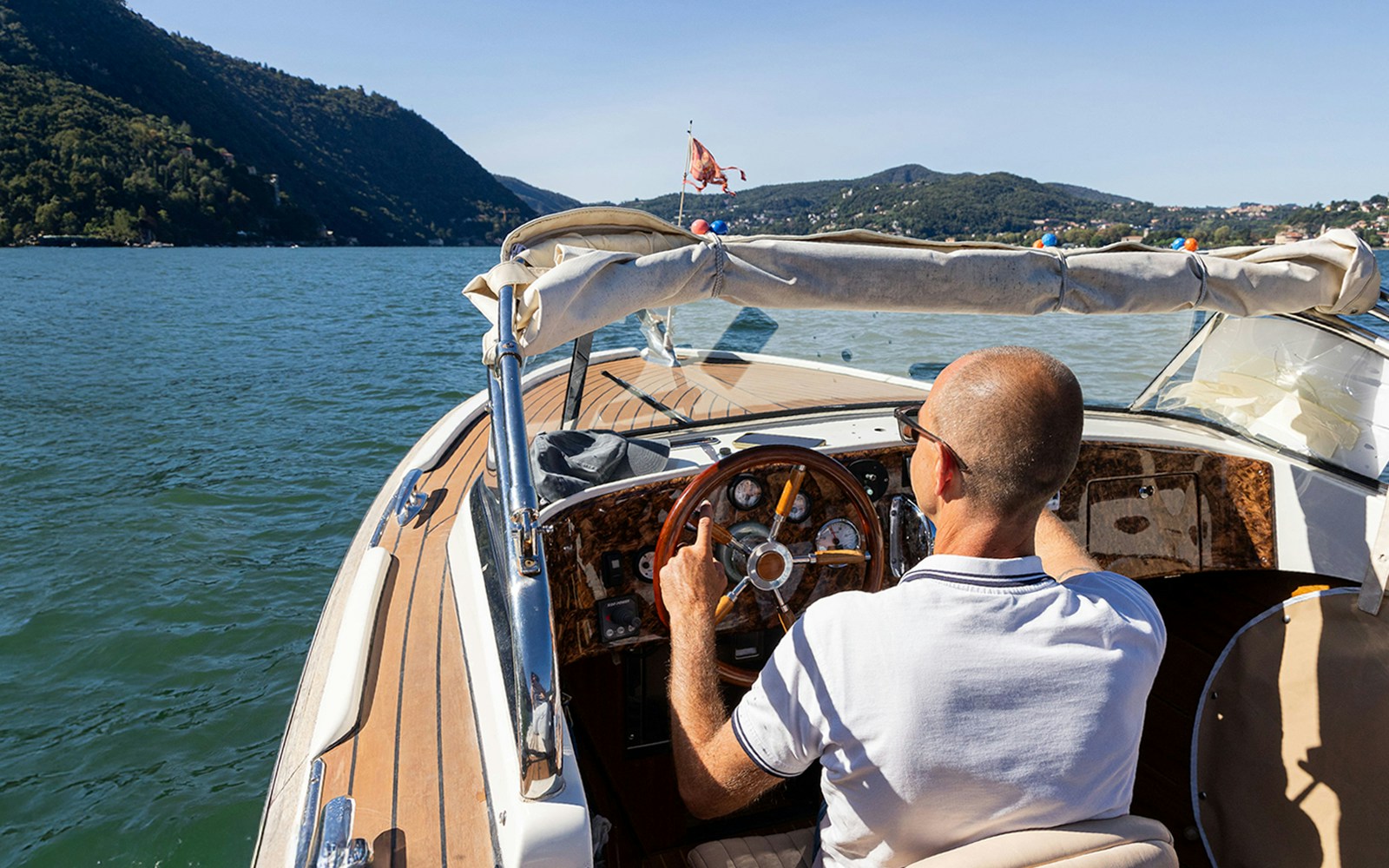Boat cruising on Lake Como with scenic mountain views.