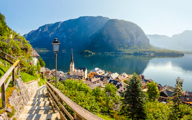 Pathway overlooking Hallstatt village and Lake Hallstatt, Austria, with mountains in the background.