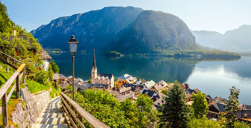 Pathway overlooking Hallstatt village and Lake Hallstatt, Austria, with mountains in the background.