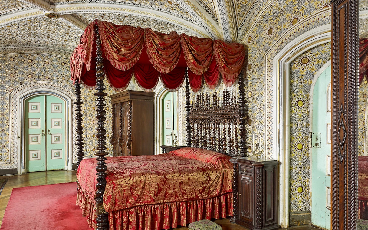Bedroom of Ferdinand II in Royal Apartments, Pena Palace, featuring ornate bed and intricate wall designs.